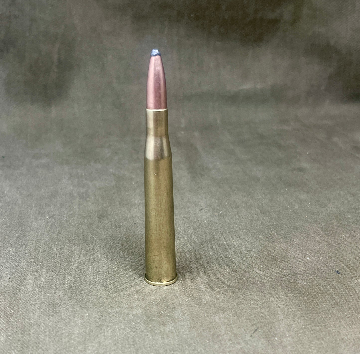 Metallic bullet on a textured gray background