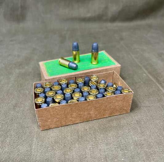 Cardboard box filled with small cylindrical objects on a gray surface