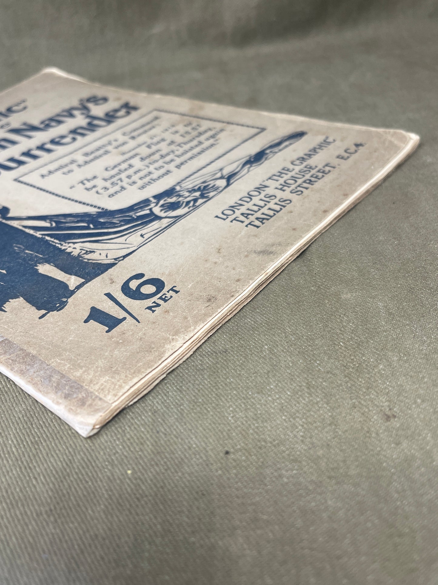 Close-up of a vintage book or magazine cover with text and illustrations on a textured surface.