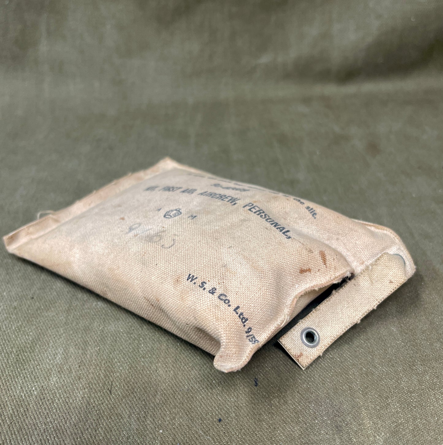 Vintage cloth pouch with text on a textured green background
