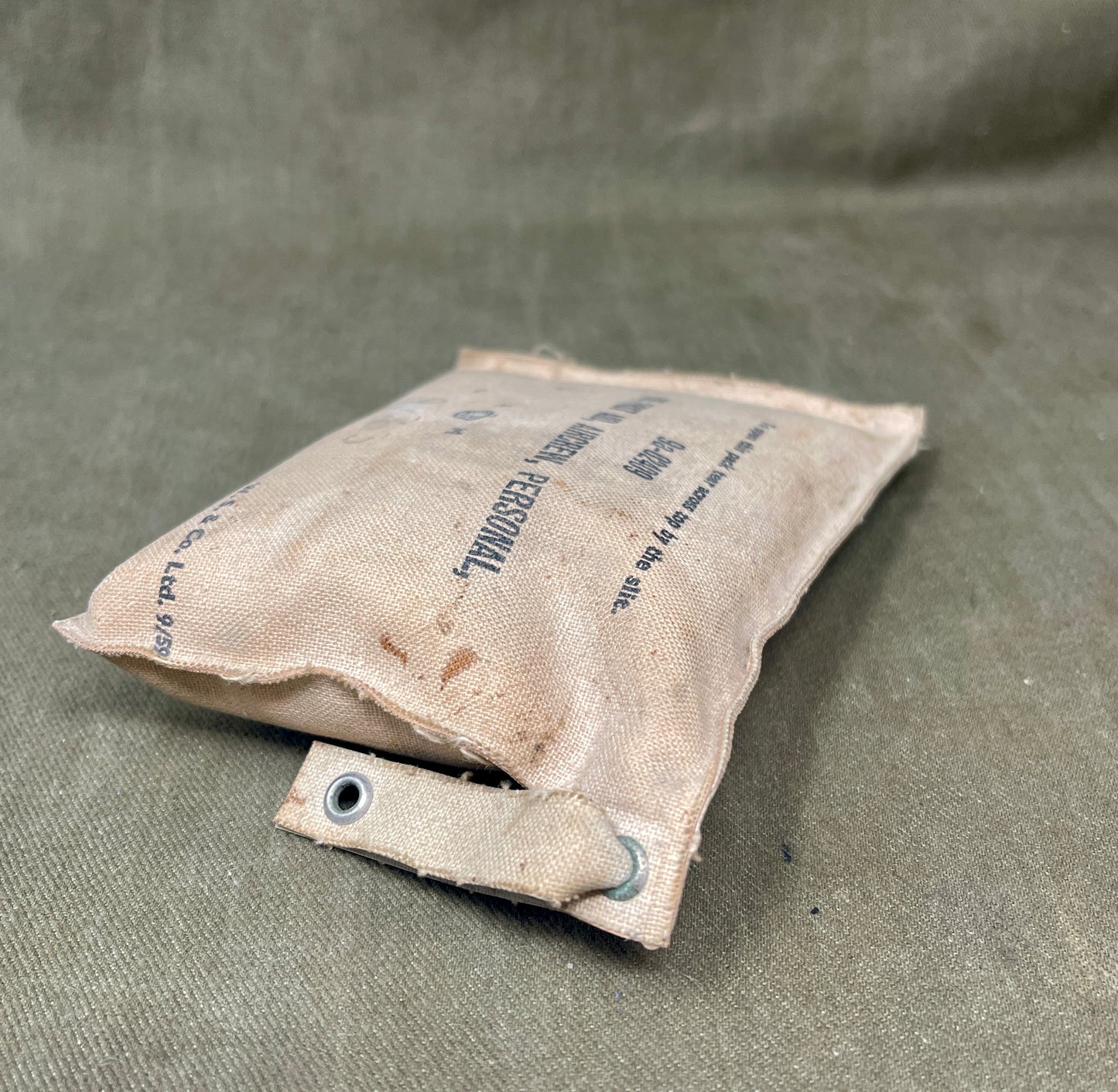 Worn-out sandbag on a textured green surface