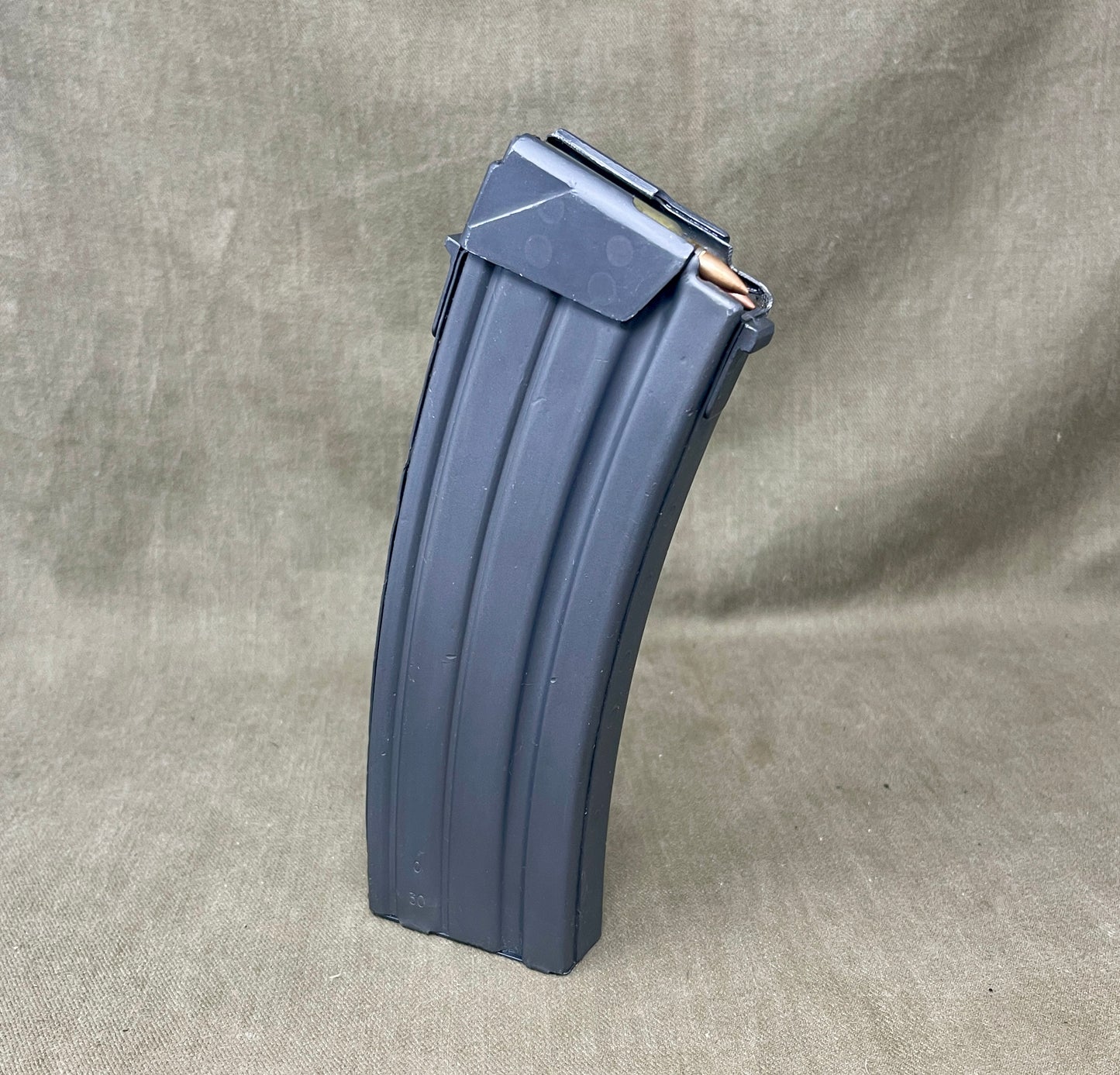 Gray rifle magazine on a beige fabric background