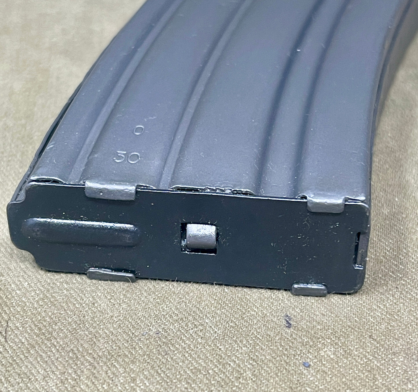 Black rifle magazine on a beige surface