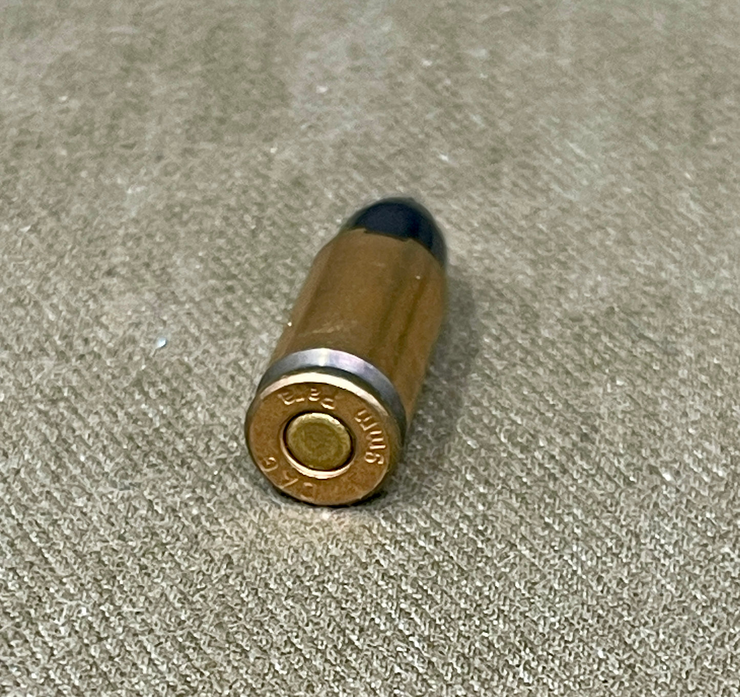 Bullet casing on a textured beige surface