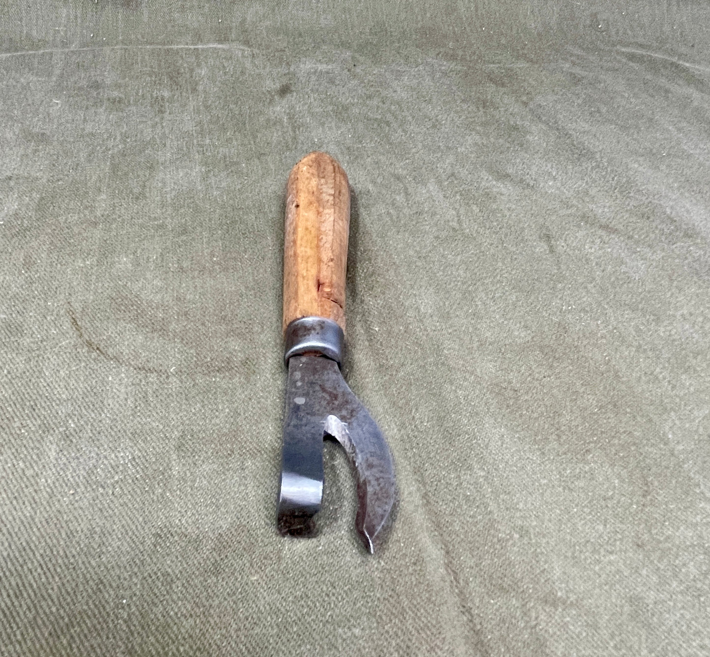 Authentic WWII German Wehrmacht can opener with original wood handle. A rare and practical piece of wartime field equipment for collectors and historians.
