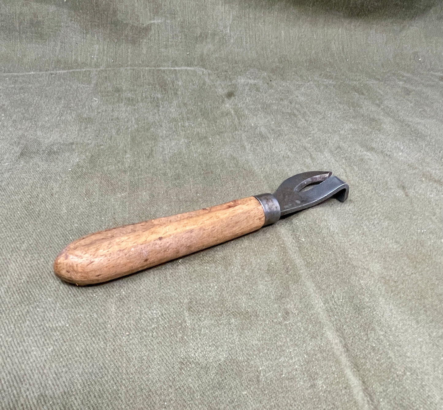 Authentic WWII German Wehrmacht can opener with original wood handle. A rare and practical piece of wartime field equipment for collectors and historians.