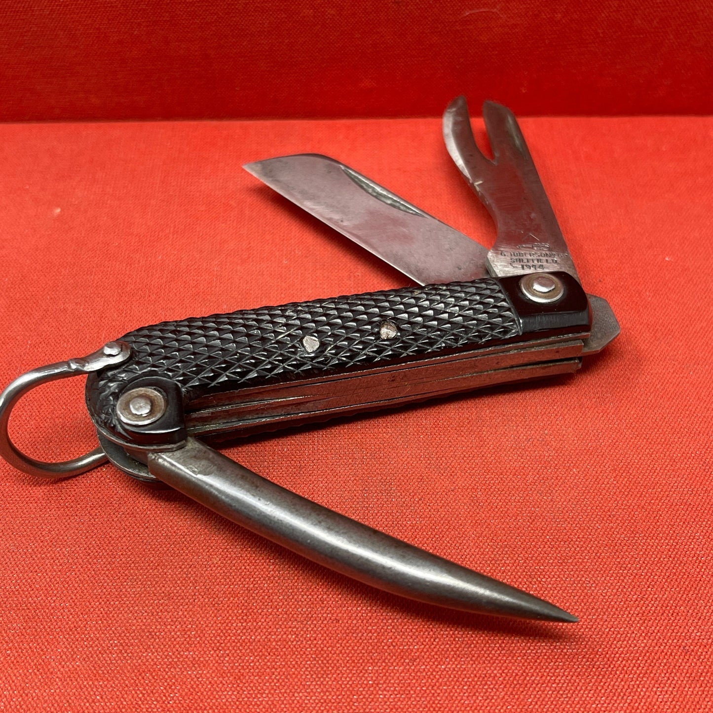 A nice example of a British 1944 Dated G Ibberson & Co military Jack Knife The blades are in good condition, the chequered Bakelite grip is intact and all the blades lock and close as they should. The steel can opener is in good condition