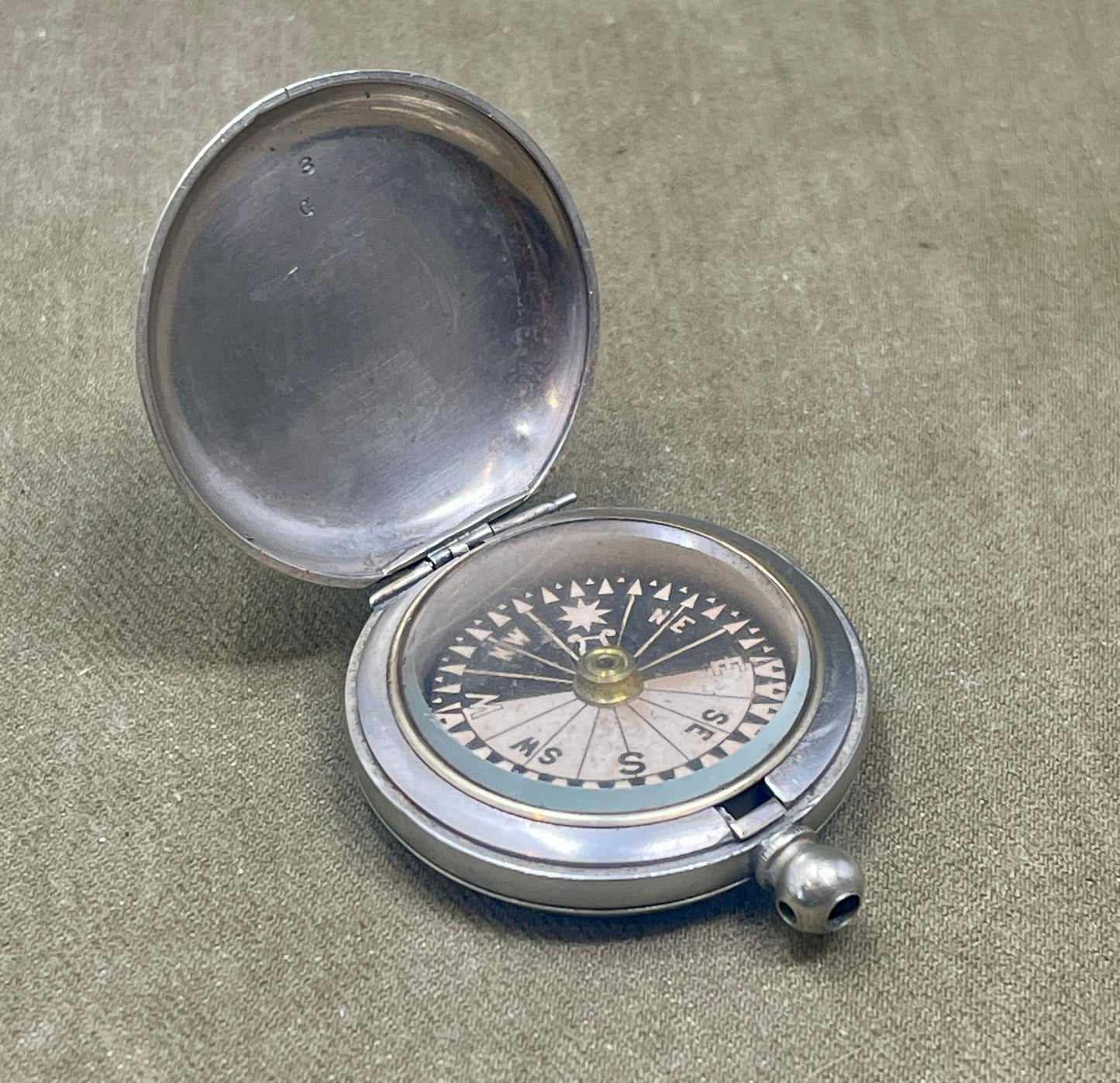 Silver compass on a textured surface