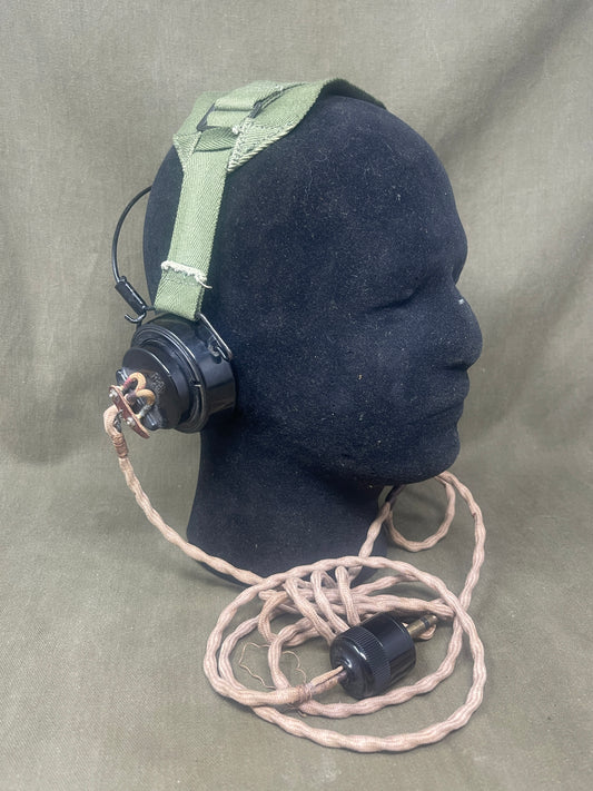 Black glove with green strap and attached cable on a gray background