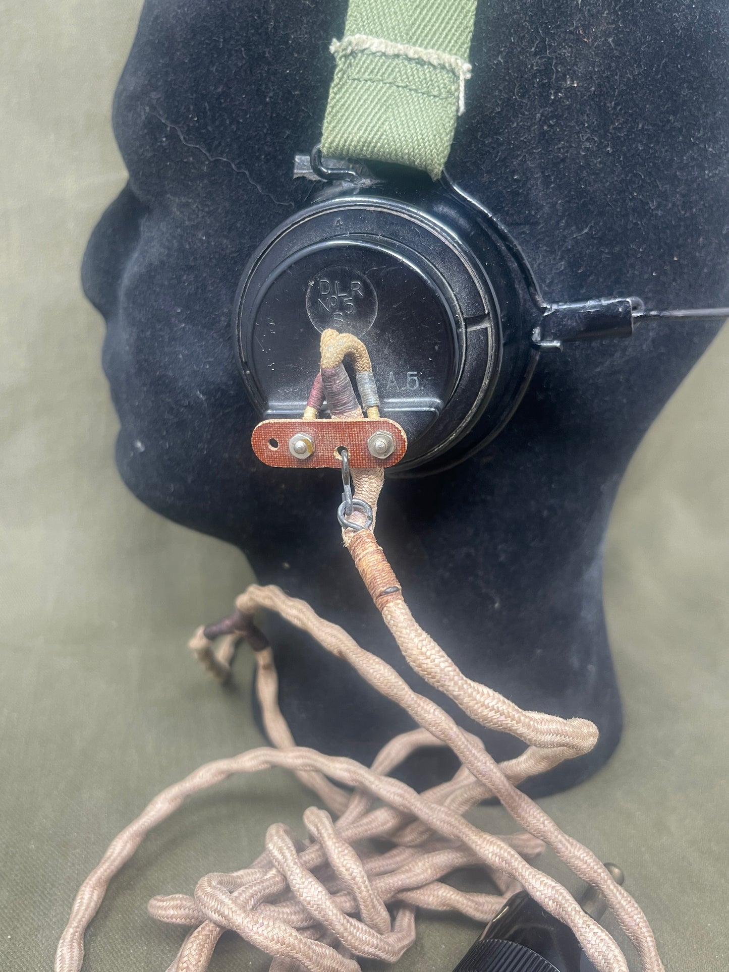 Close-up of a black watch with a brown strap on a dark surface