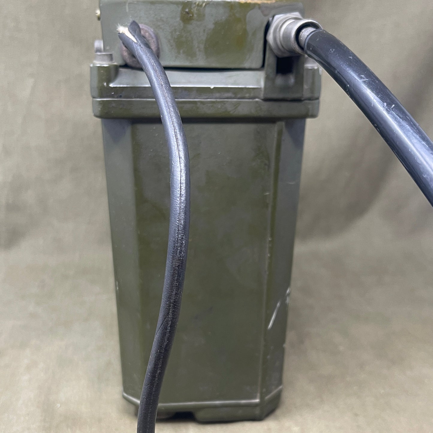 Rectangular metal device with cables on a beige background