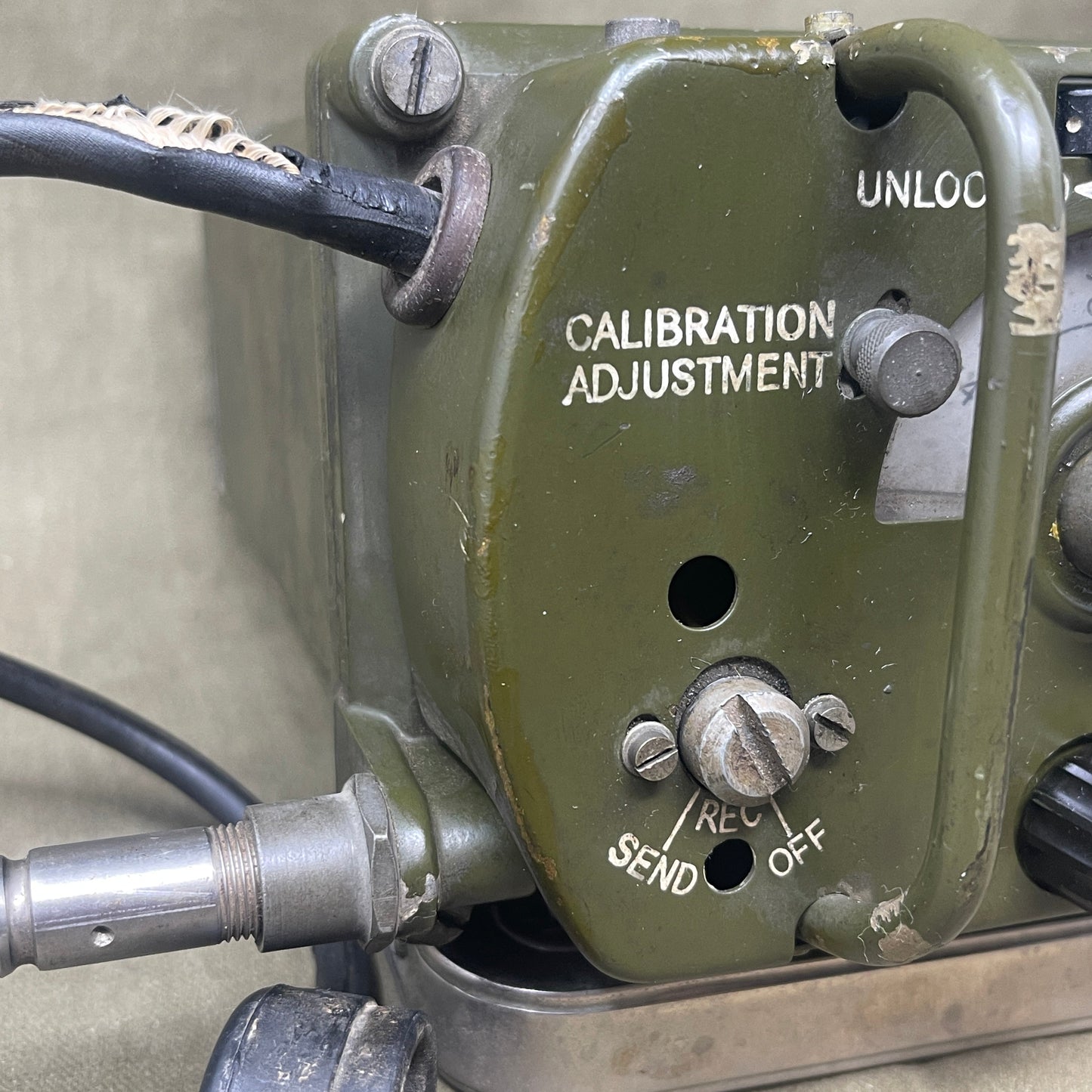 Close-up of a military-style communication device with various knobs and labels.