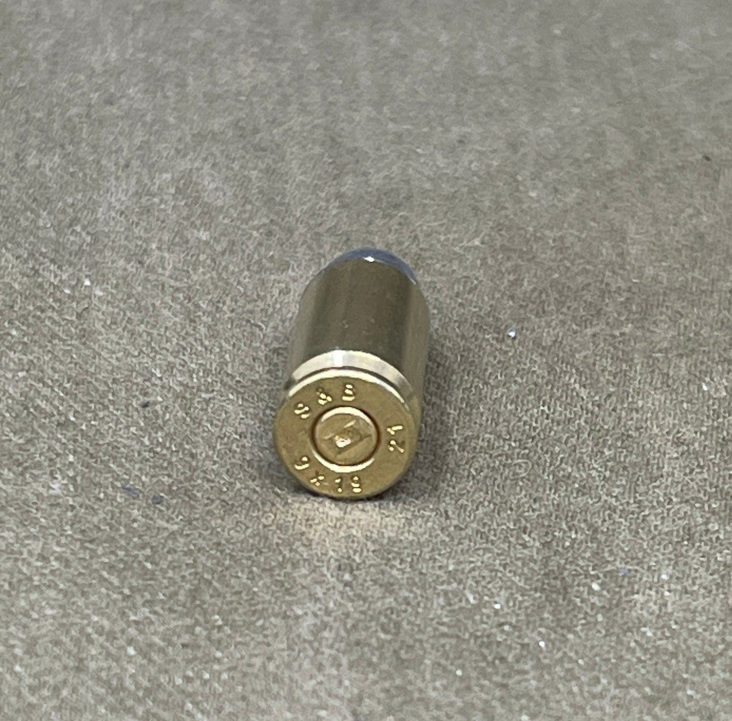 Bullet casing on a gray textured surface