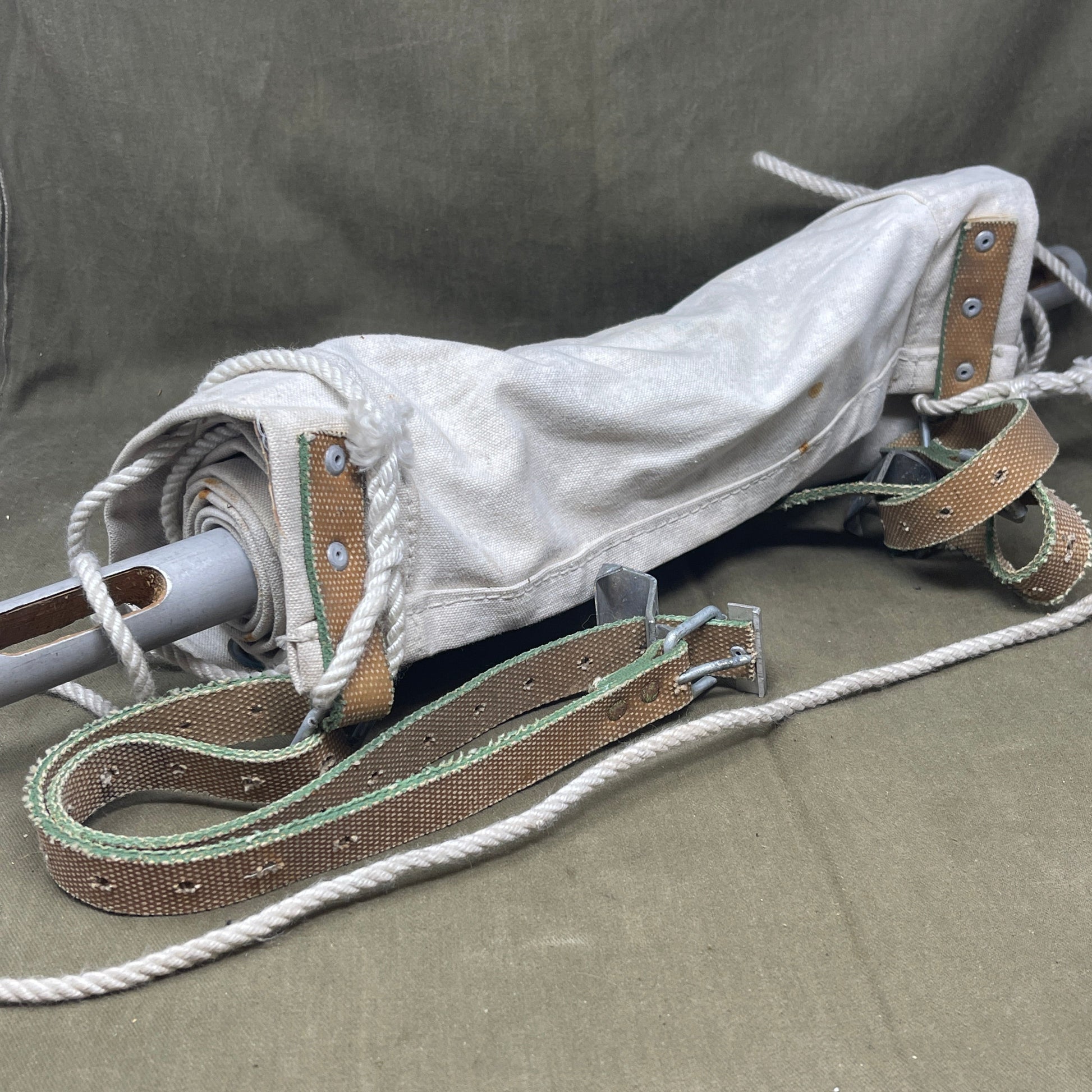 White crutch with brown straps on a gray background