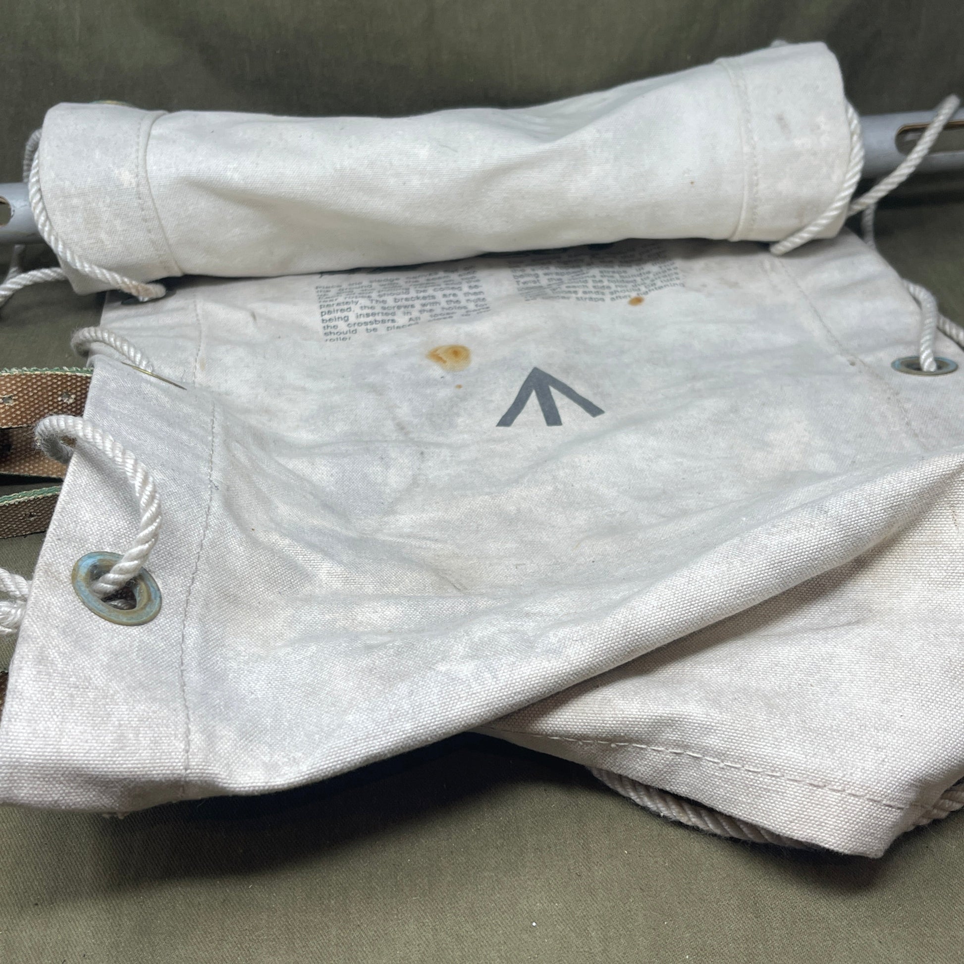 White jacket with a logo on a hanger against a neutral background