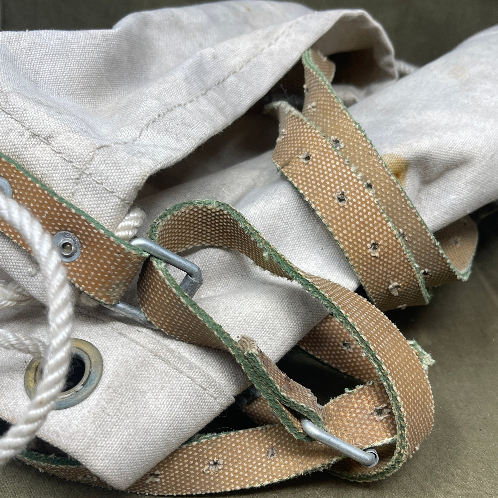 Close-up of a white shoe with brown laces and straps on a gray background