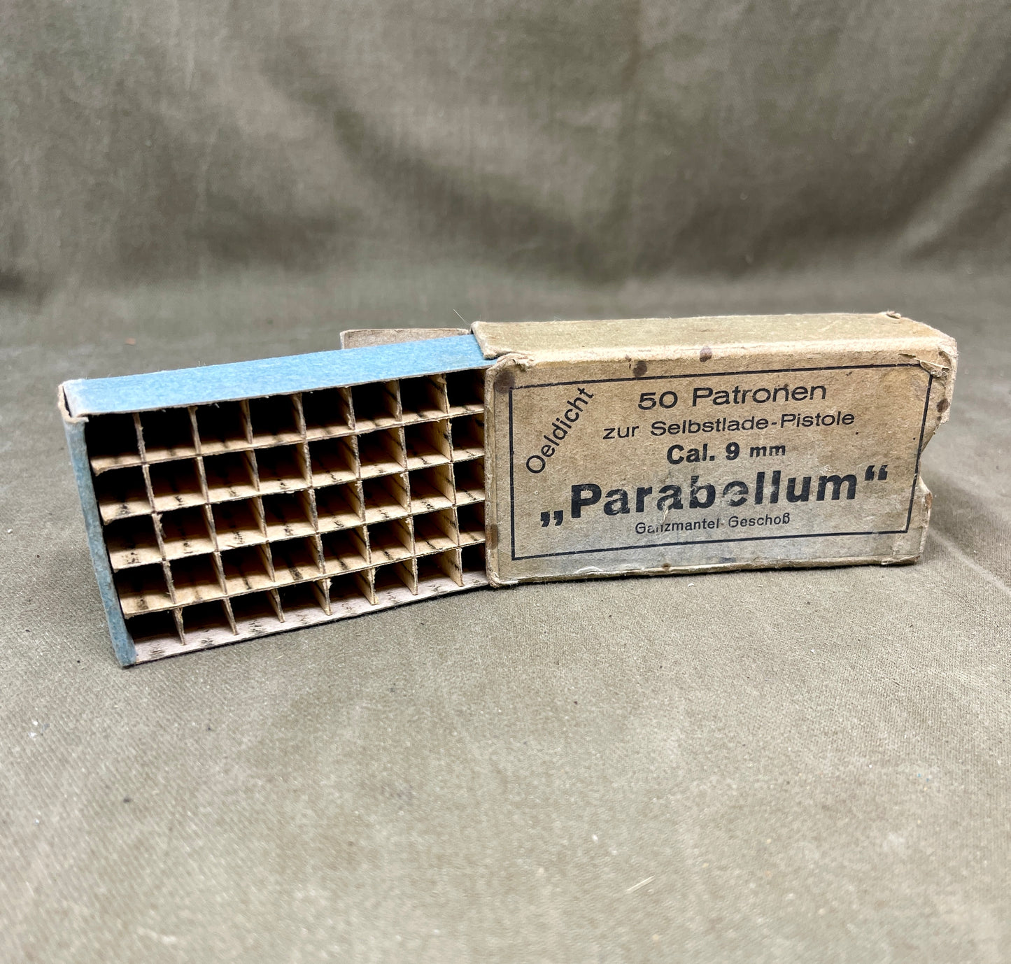 Vintage Parabellum ammunition box with a magazine on a gray background