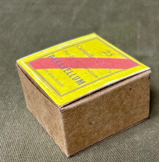 Small cardboard box with a yellow label on a textured surface