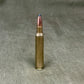 Metallic rifle bullet on a textured gray background