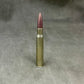 Single rifle bullet on a textured gray background