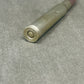 Metallic cylindrical object with 'U.S.' engraving on a gray surface