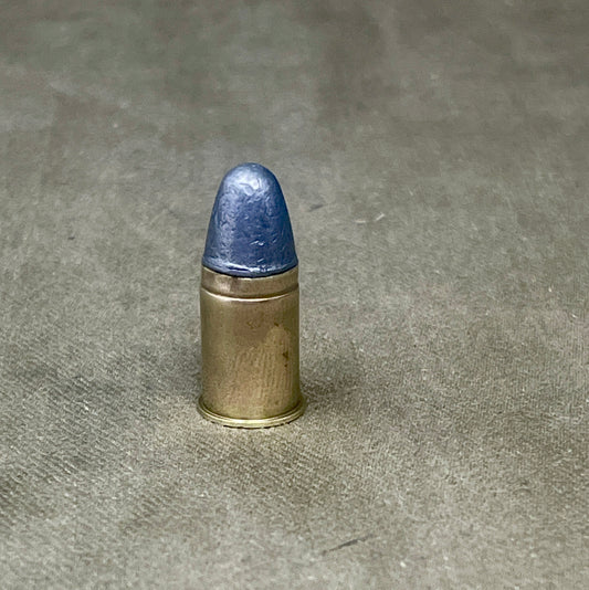 Bullet with blue tip on a gray concrete surface