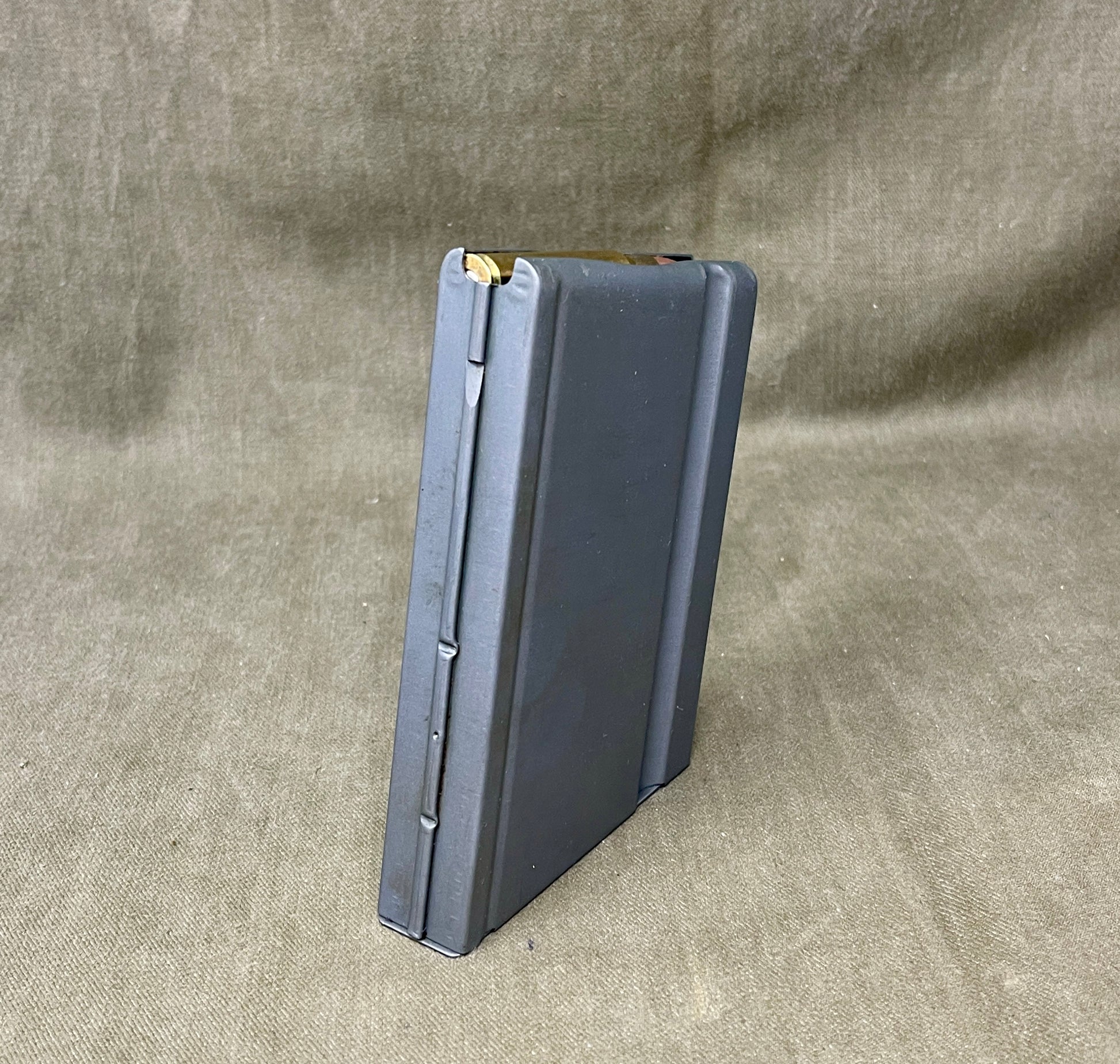 Black rifle magazine on a beige fabric background