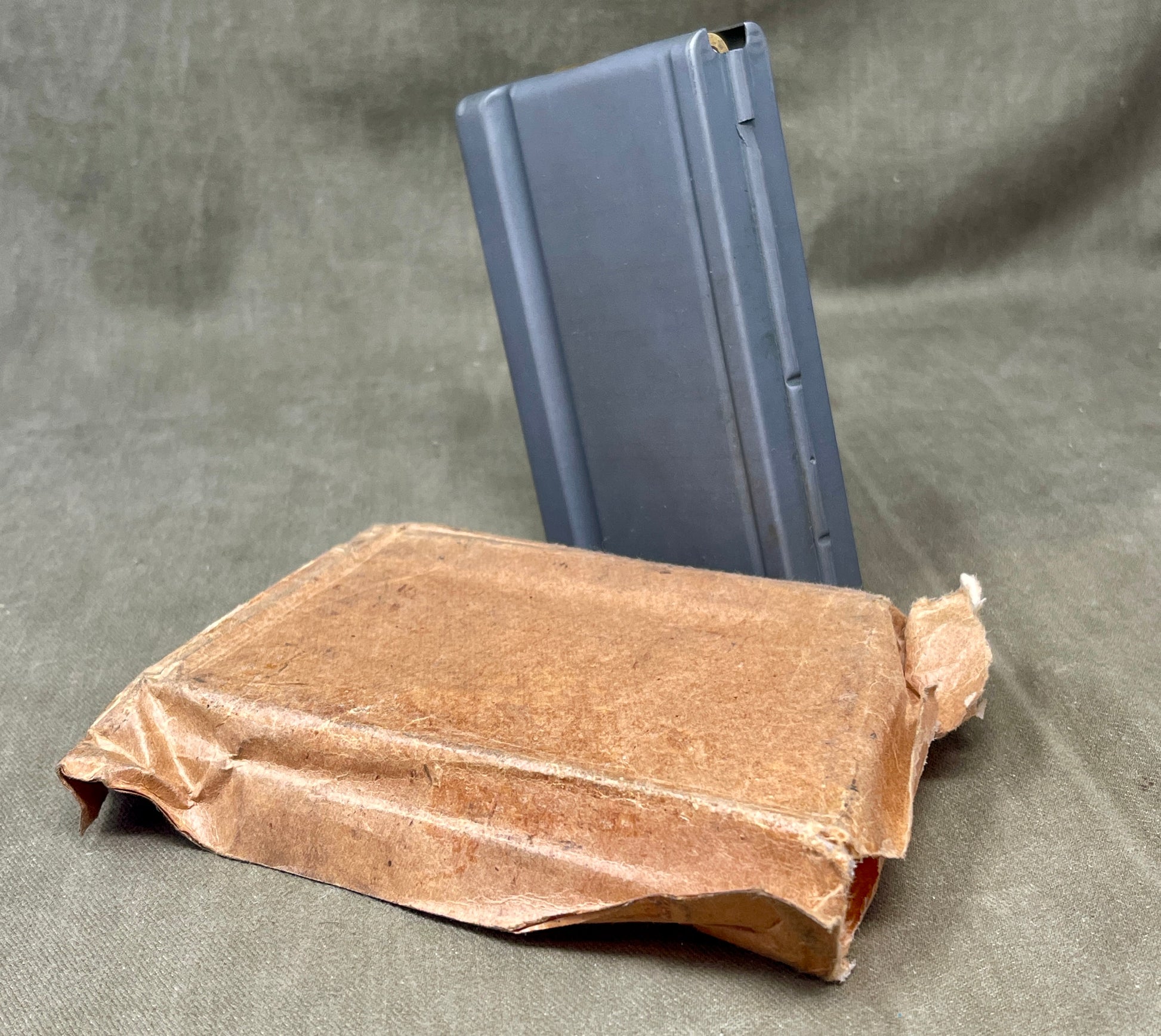 Brown paper bag with a blue metal object on a gray background