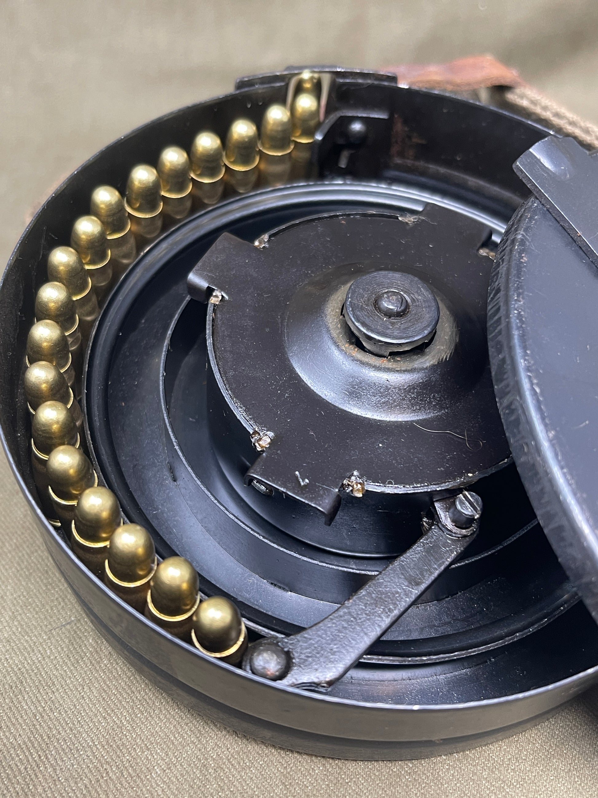 Close-up of a mechanical component with gears and a central shaft on a beige background