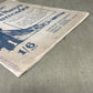 Close-up of a vintage book or magazine cover with text and illustrations on a textured surface.