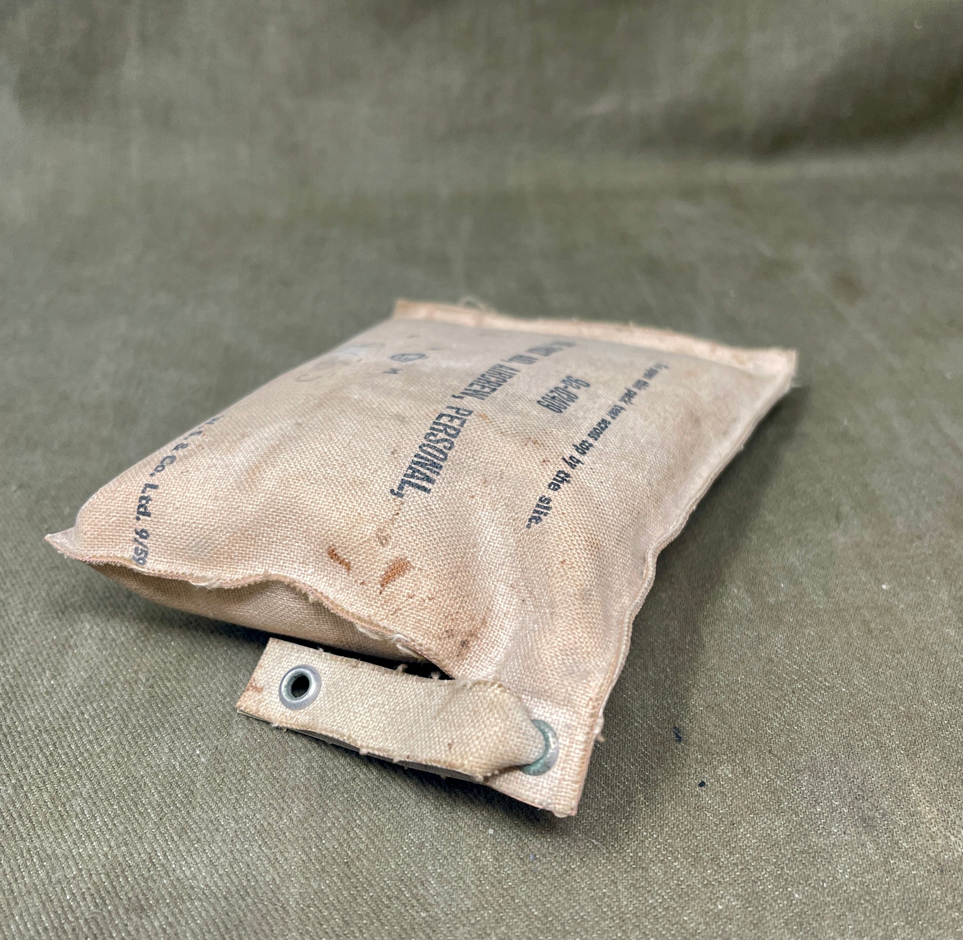 Worn-out sandbag on a textured green surface