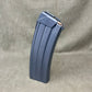 Gray rifle magazine on a beige fabric background