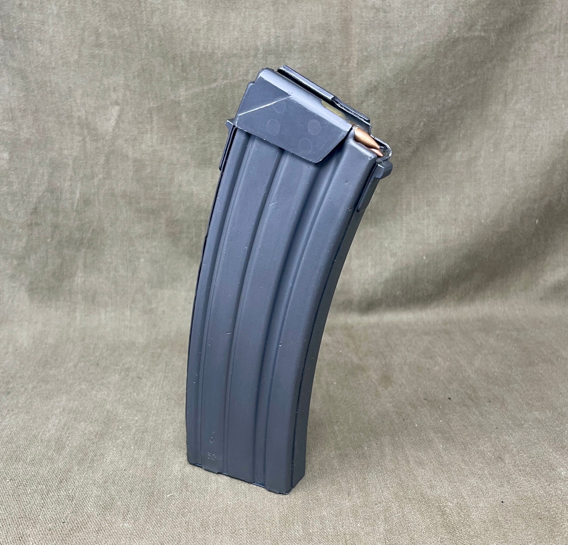 Gray rifle magazine on a beige fabric background