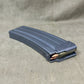Gray rifle magazine with ammunition on a beige fabric background