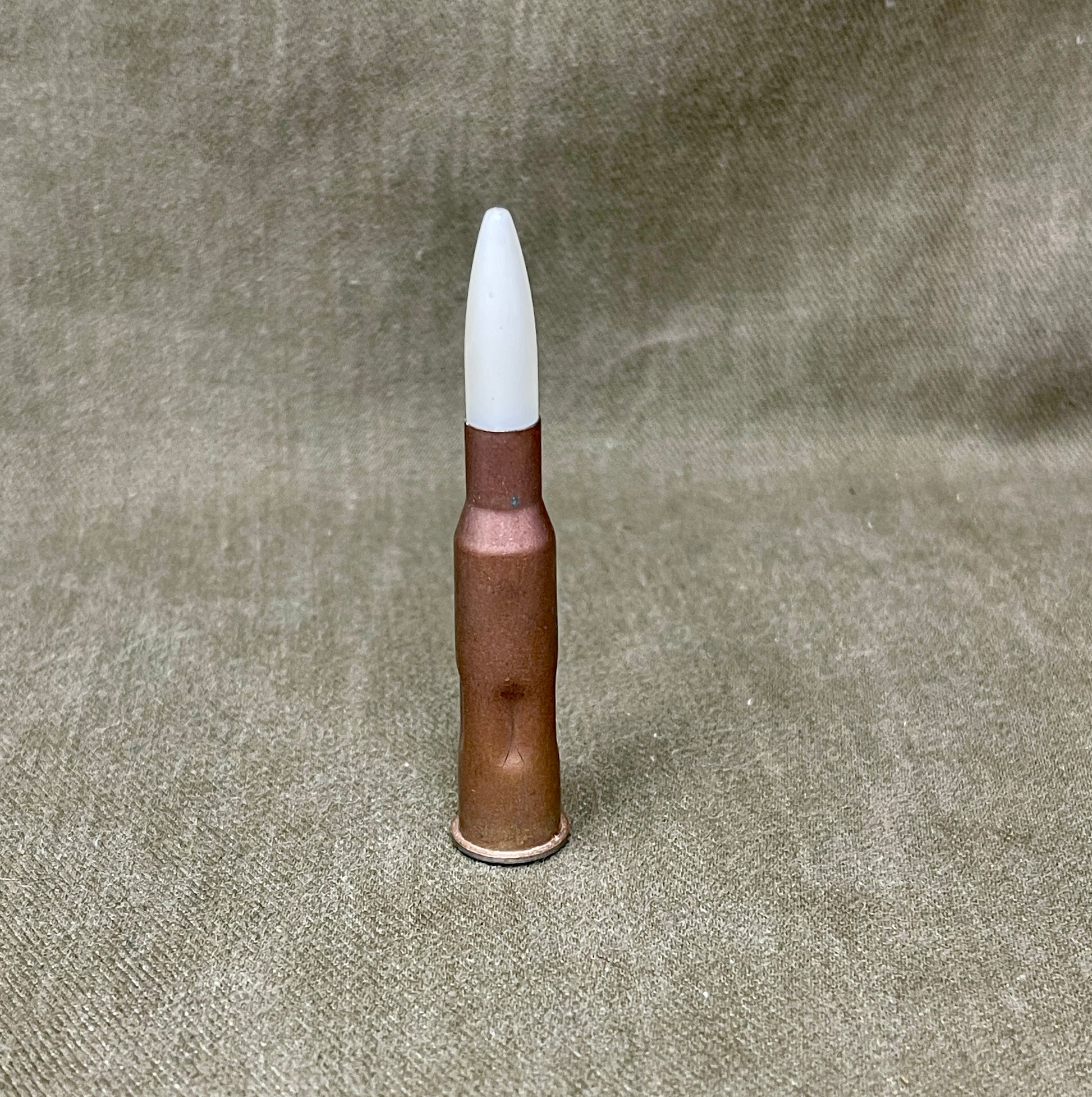Bullet with a white tip on a textured gray background