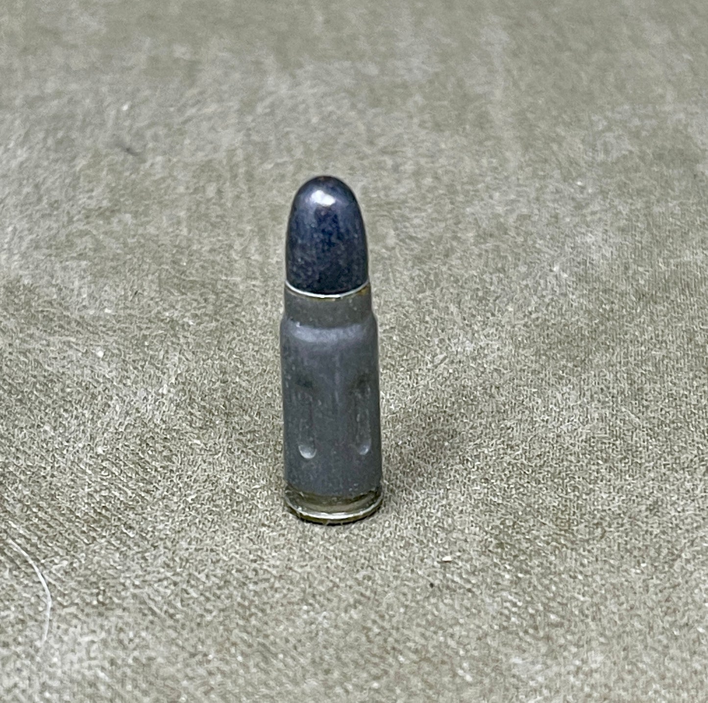 Bullet casing on a textured gray surface