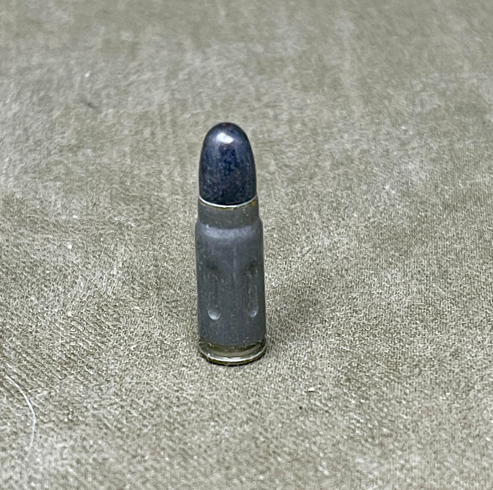 Bullet casing on a textured gray surface