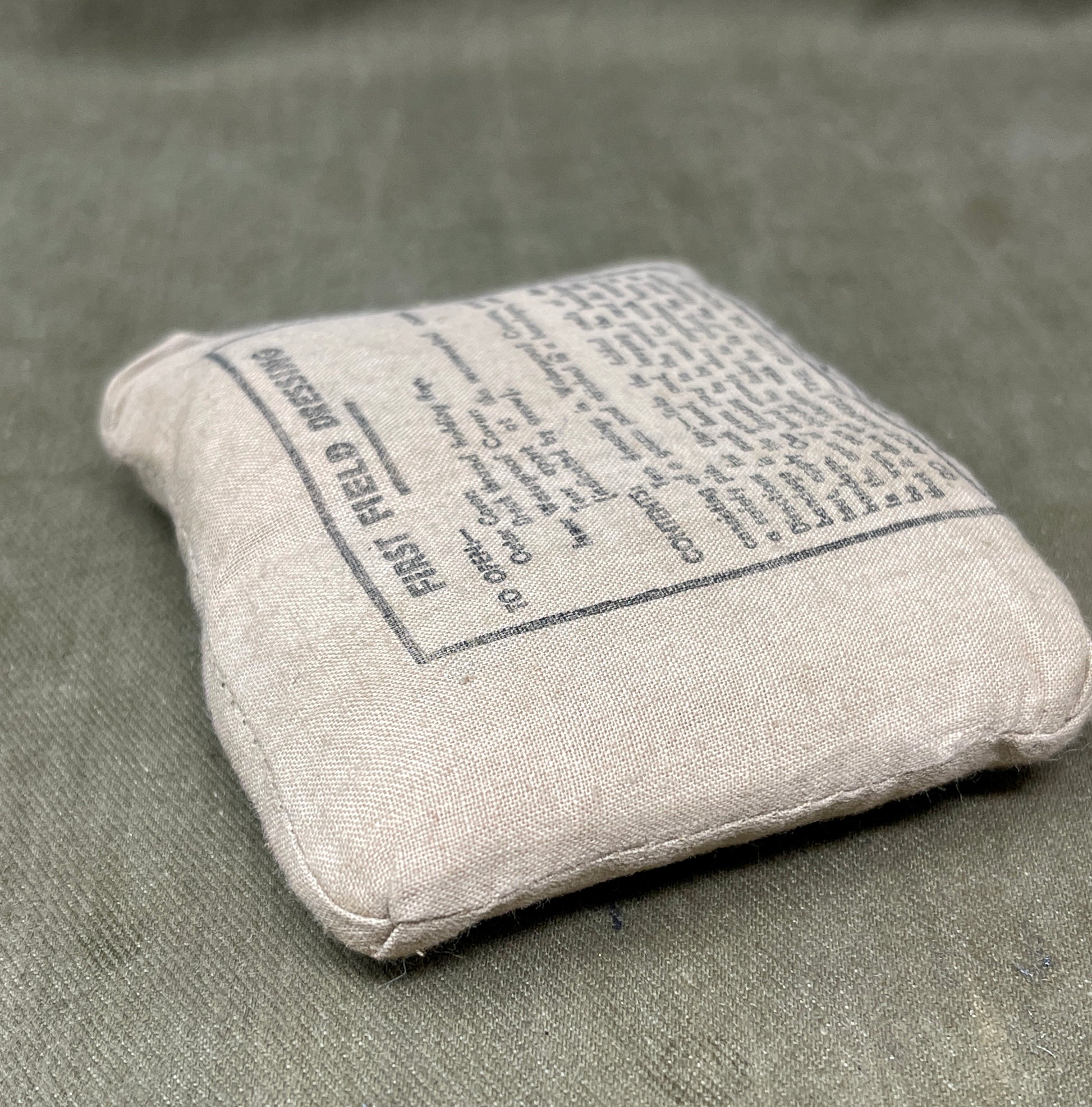 Gray fabric pouch with text on a matching gray background