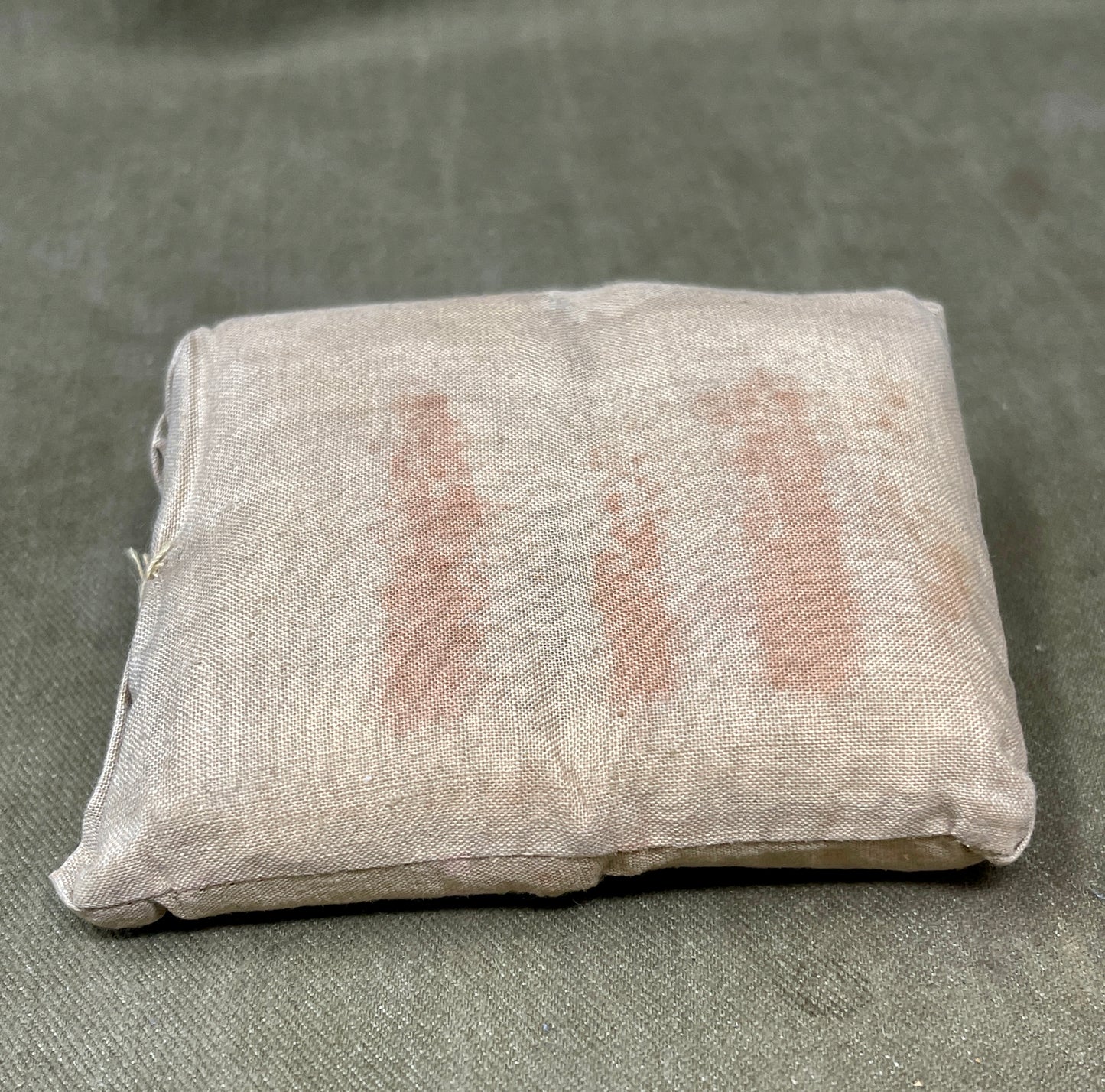 Fabric sample with red stains on a gray background