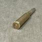 Metallic bullet casing on a gray textured surface