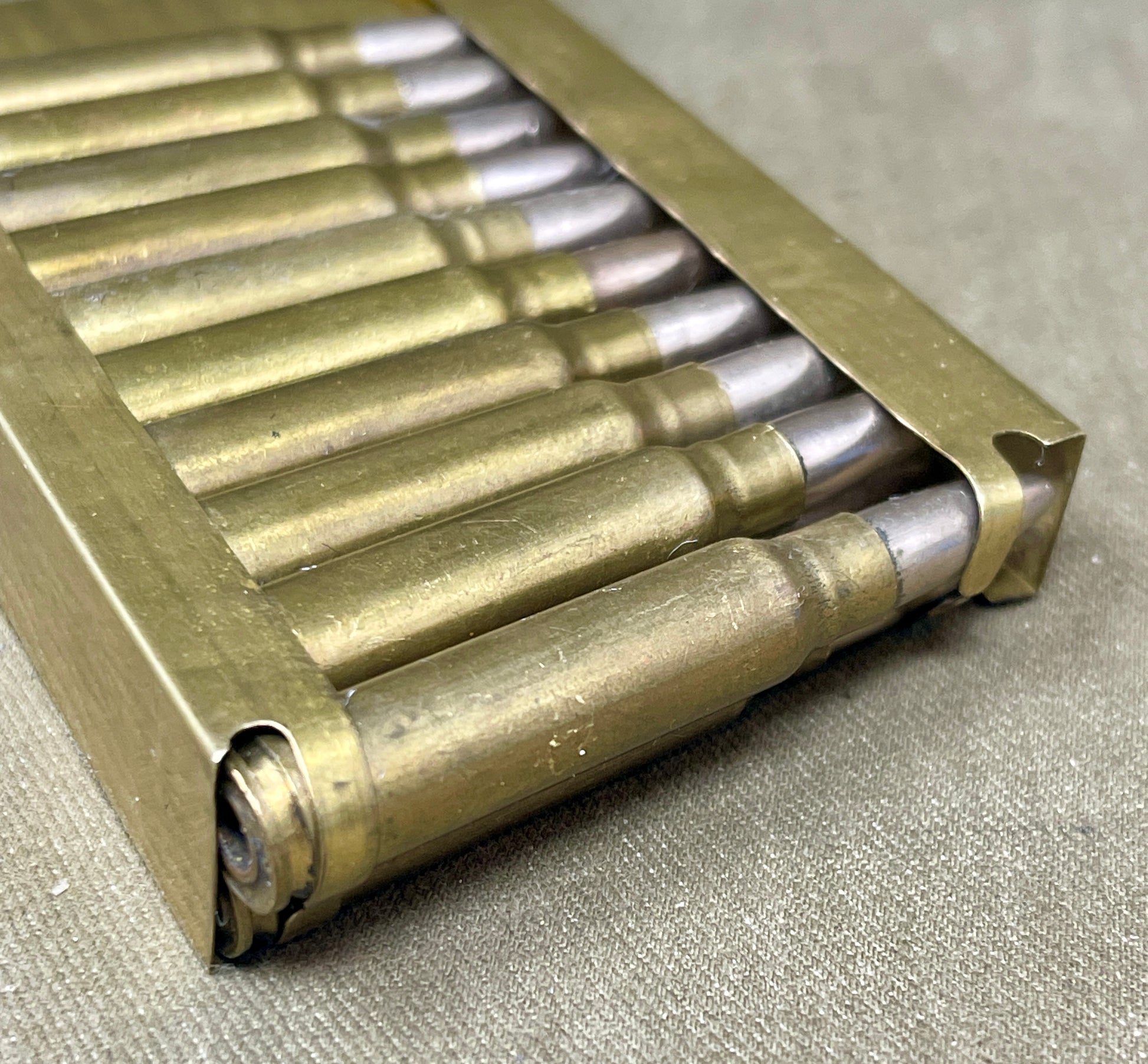 Metallic ammunition casing with bullets on a textured surface