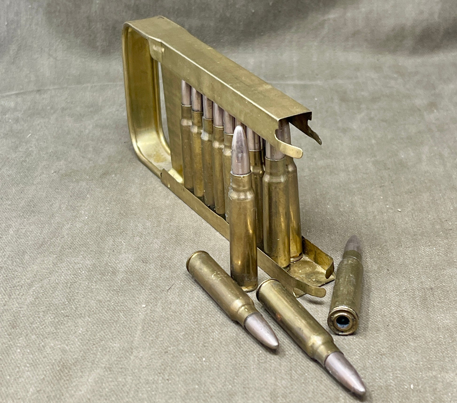 Gold ammunition clip with bullets on a gray fabric background