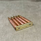Metallic cartridge holder with bullets on a textured surface