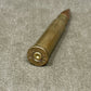Bronze-colored bullet casing on a gray surface