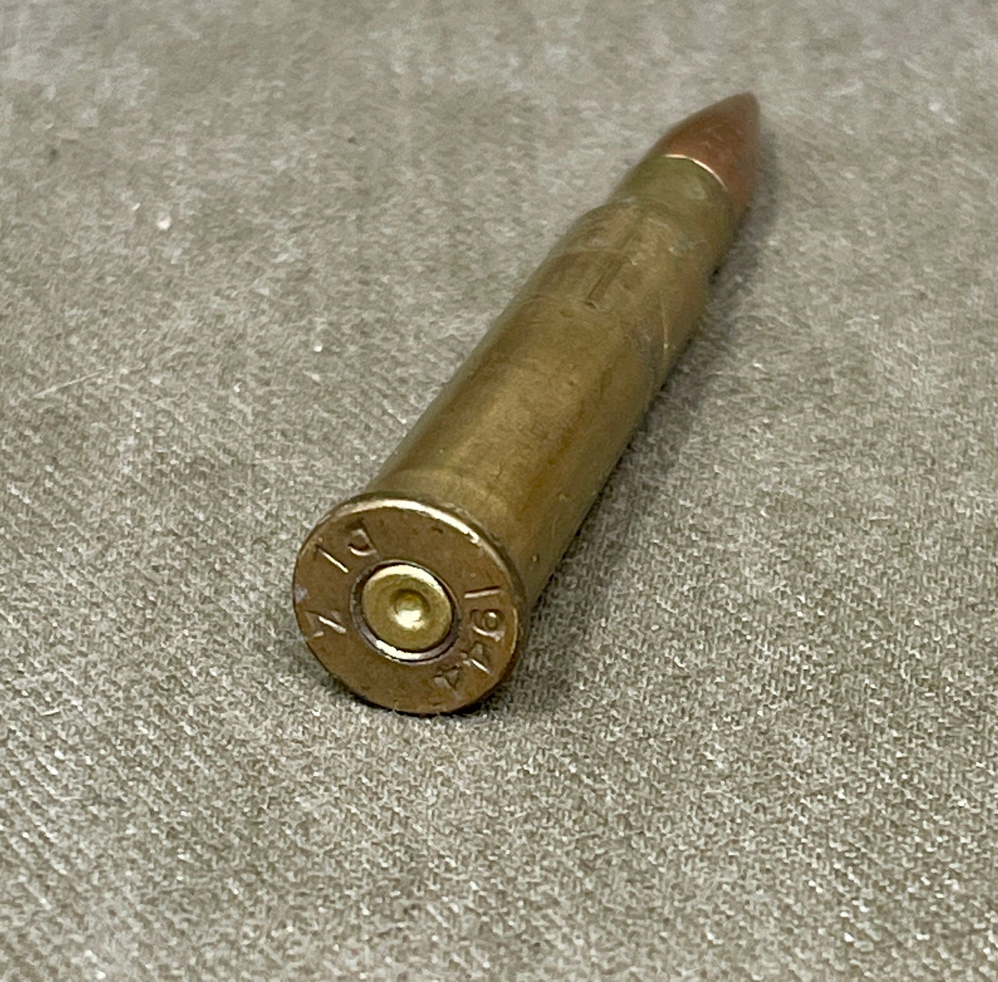 Bronze-colored bullet casing on a gray surface
