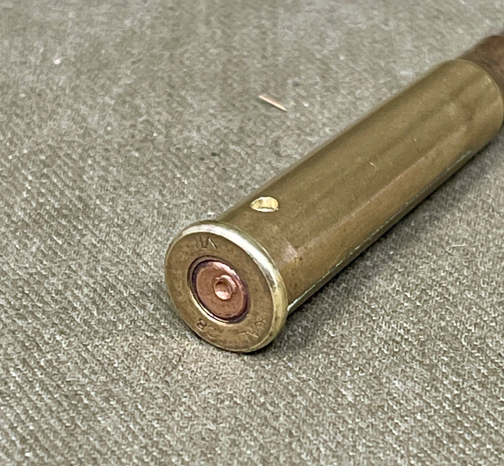 Close-up of a rifle cartridge on a textured surface