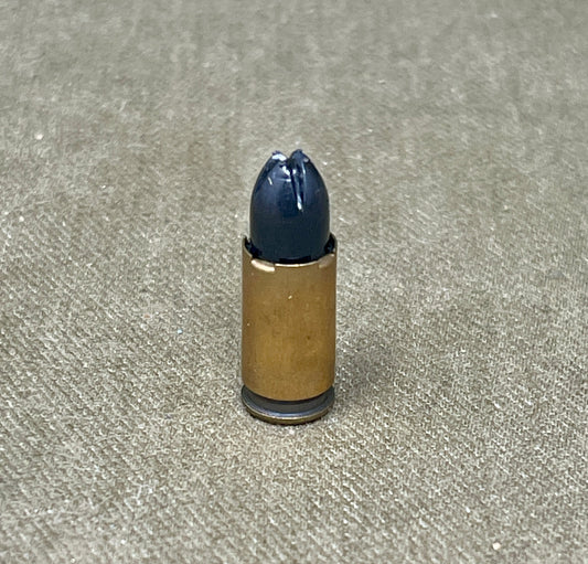 Bullet casing with a blue projectile on a textured surface