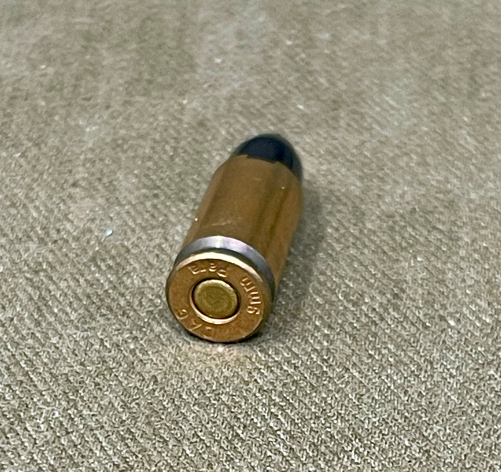 Bullet casing on a textured beige surface