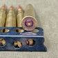 Close-up of ammunition and a reloading tool on a textured surface