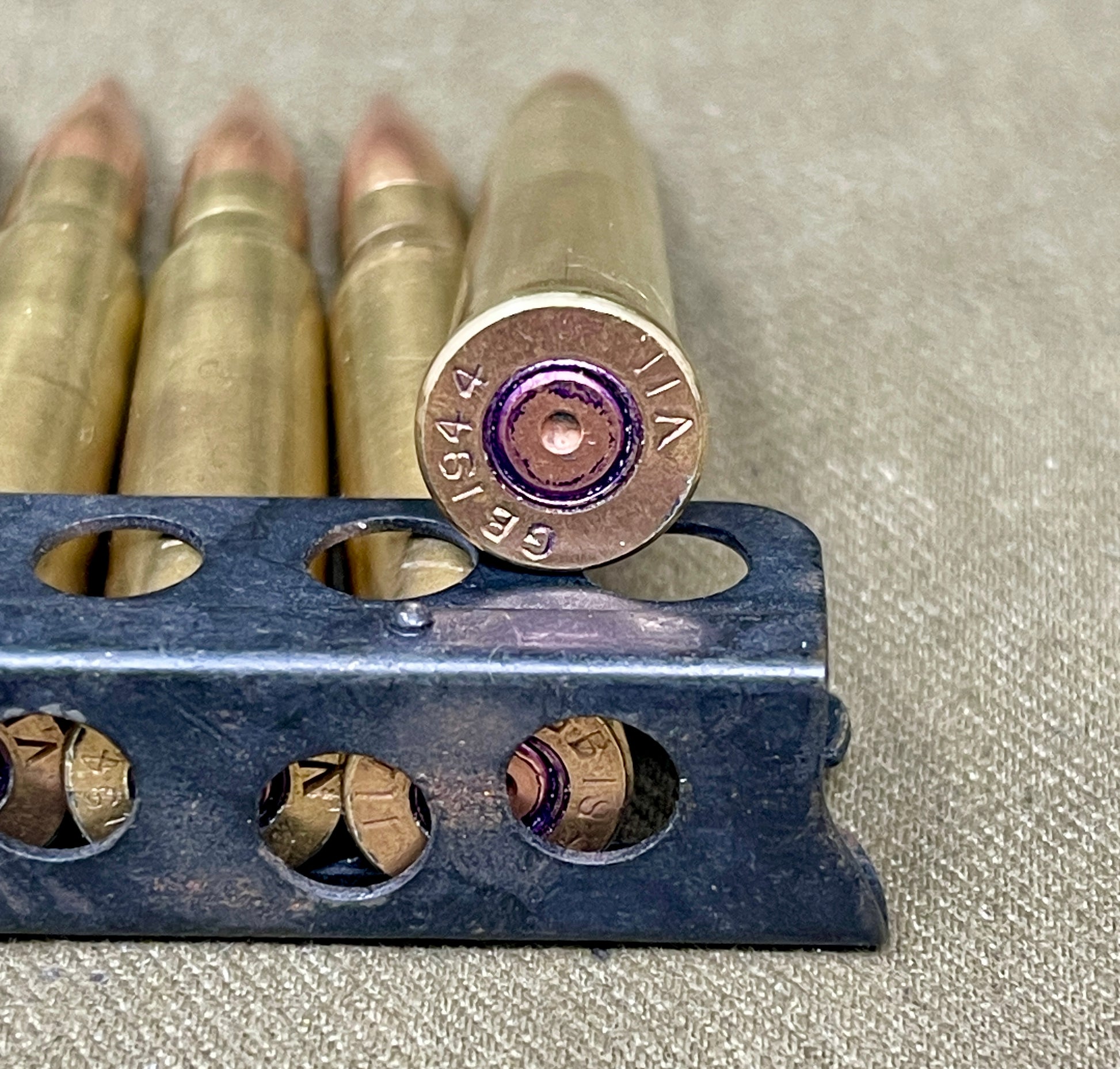 Close-up of ammunition and a reloading tool on a textured surface